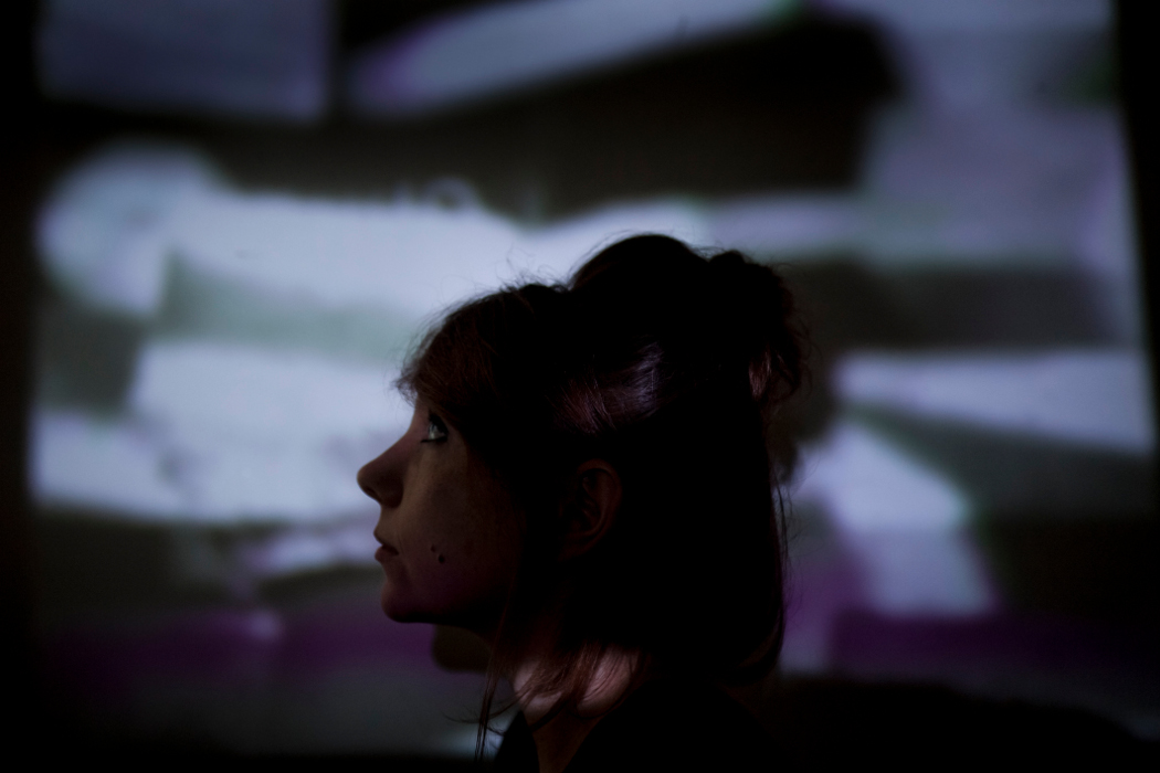 Poppy Ackroyd by Kat Gollock, artist silhoette in foreground with film projected behind her