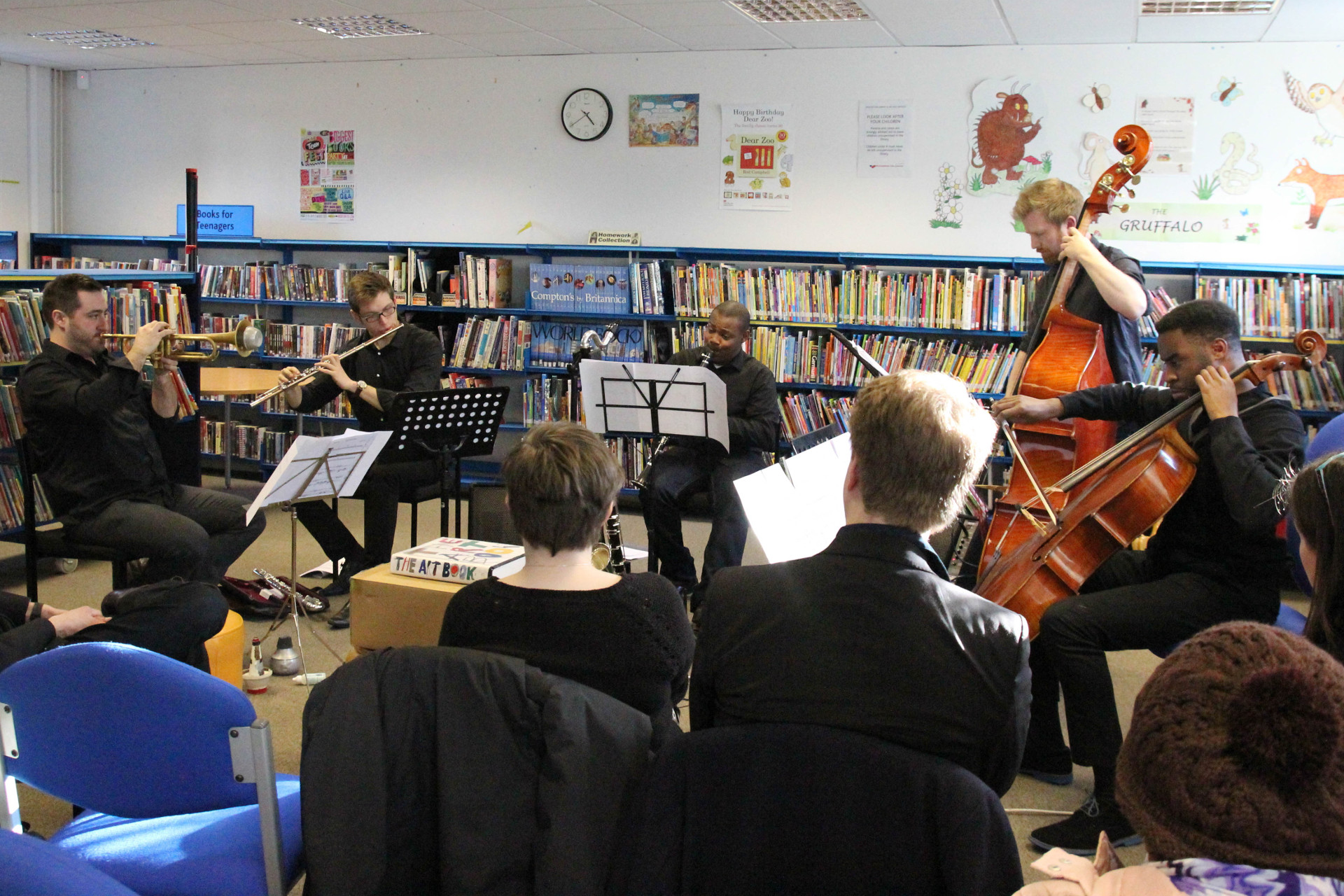 for-Wards performance Aston Library, five musicians performing surrounded by bookshelves