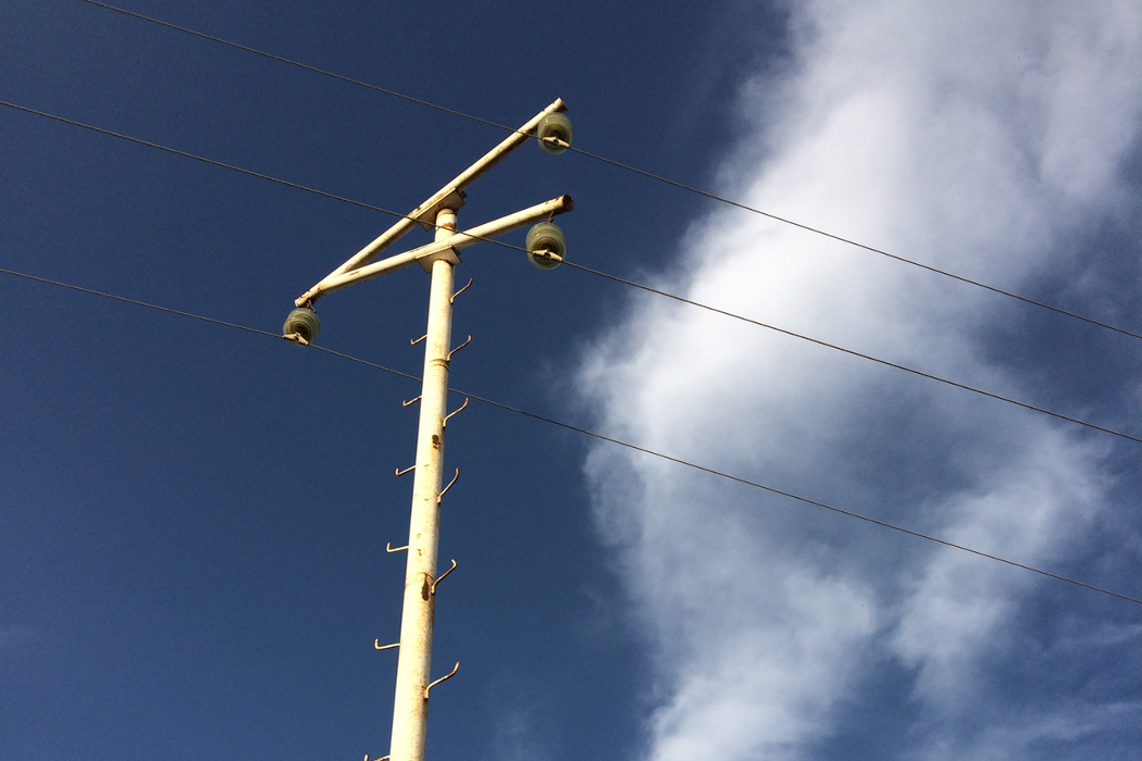 nula.cc - telegraph pole against blue sky with white fluffy cloud