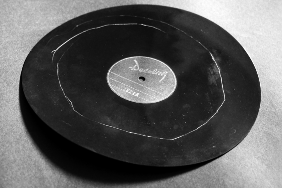 Stephan Mathieu - Radiance Interview, bent black record with white circular scratch mark