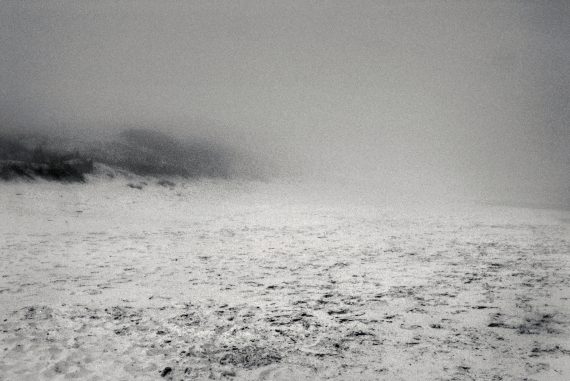 Sergio Merce - be nothing, black and white image of an empty beach covered in haze