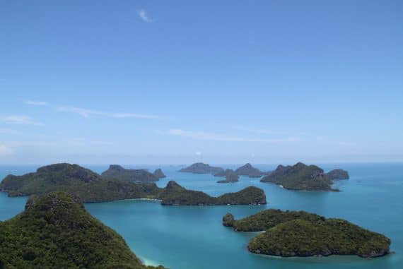 Archipelago by Dmitry Teslya, archipelago of small green islands in a blue sea beneath a blue sky