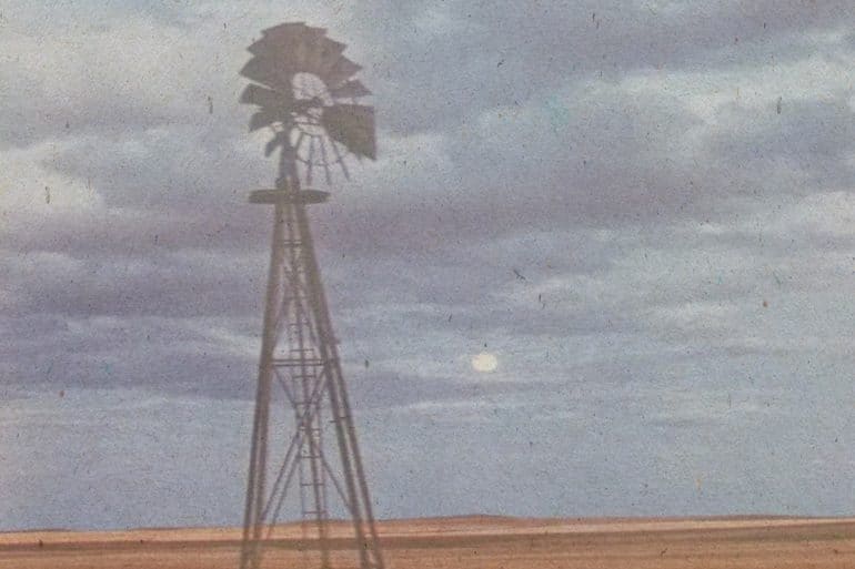 Mark So - And suddenly from all this there came some horrid music, old photograph of a metal windmill against a cloudy sky and flat prairie landscape