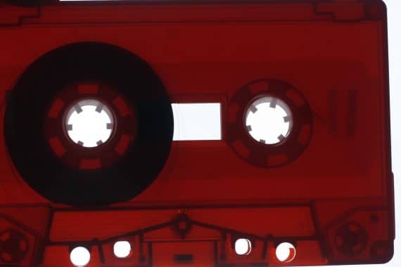 Grisha Shakhnes - The distance between a word and a deed, closeup of a translucent dark red cassette tape