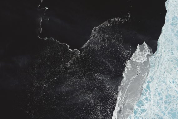 Stephan Mathieu - RADIANCE XII- PACIFIC, colour-adjusted bird's eye view of a coastline in black and cyan.