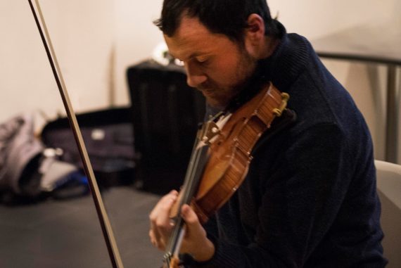 Morgan Evans-Weiler - Unfinished Variations, the artist in a dark jumper holding a violin.