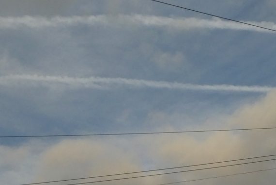 Kate Carr - I Ended Out Moving To Brixton, contrails, clouds, and telegraph wires against a blue sky.