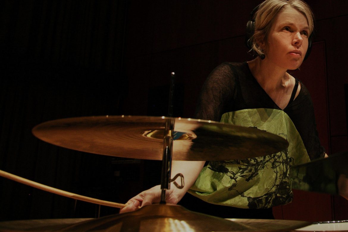 Vanessa Tomlinson - The Space Inside, artist with headphones playing cymbals.